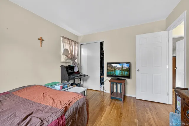 a bedroom with a bed and a flat tv screen on a dresser