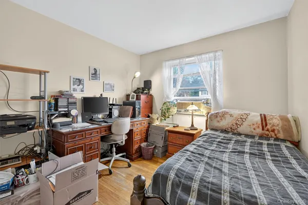 a bedroom with two beds and a computer on the desk next to a window