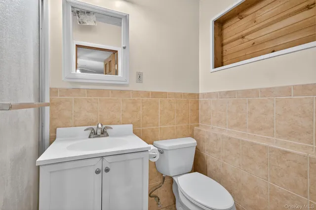 a bathroom with a sink mirror and toilet