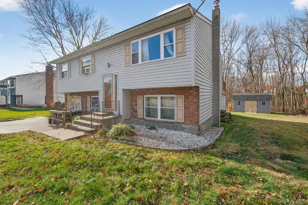 a view of a house with backyard and sitting area