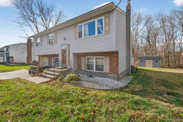 a view of a house with backyard and sitting area