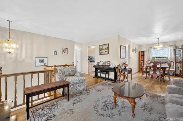 a living room with furniture a wooden floor and a chandelier