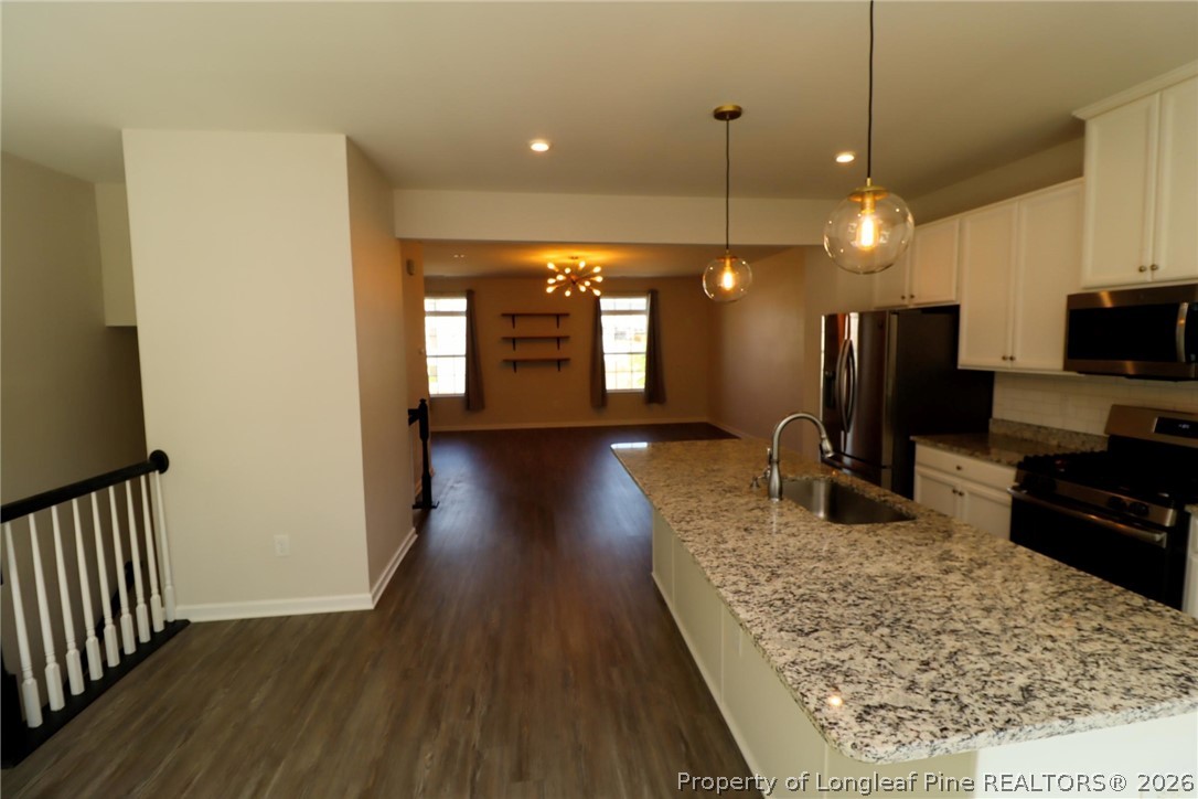 244 Amber Acorn Avenue Raleigh, NC 27603 - Photo 11 of 50 a view of a kitchen with a sink and a wooden floor