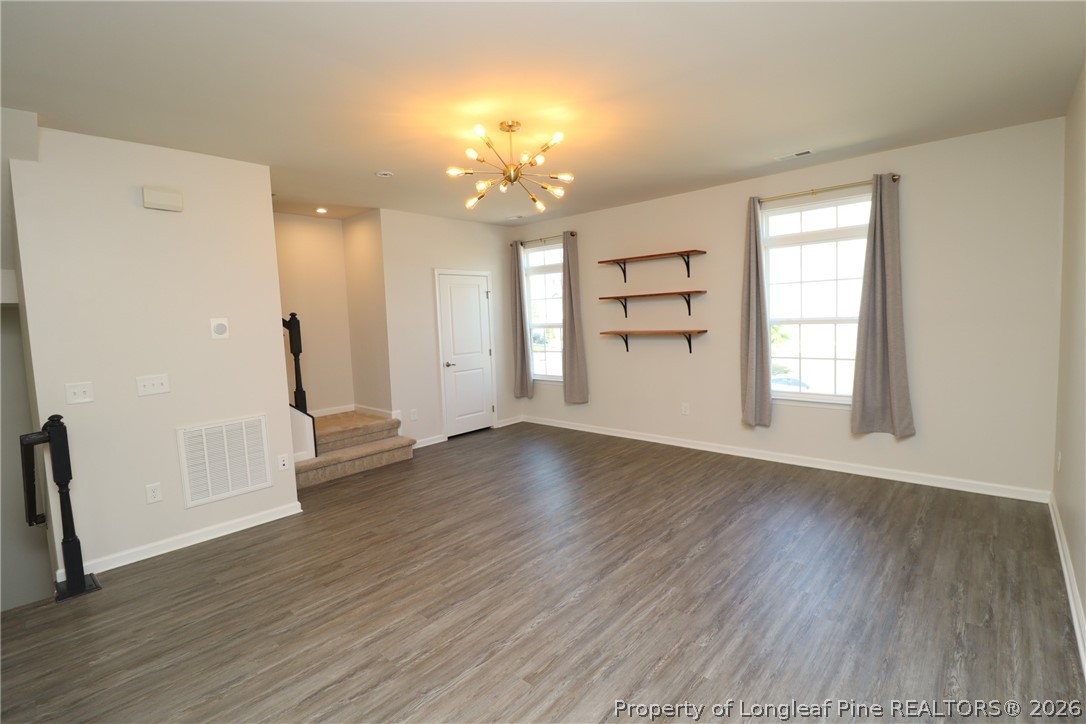244 Amber Acorn Avenue Raleigh, NC 27603 - Photo 12 of 50 an empty room with wooden floor and windows