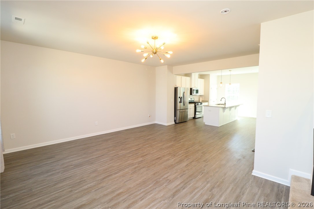 244 Amber Acorn Avenue Raleigh, NC 27603 - Photo 14 of 50 a view of a livingroom with a dishwasher a stove top oven with wooden floor