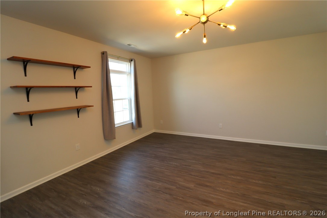 244 Amber Acorn Avenue Raleigh, NC 27603 - Photo 15 of 50 a view of an empty room with a window and wooden floor