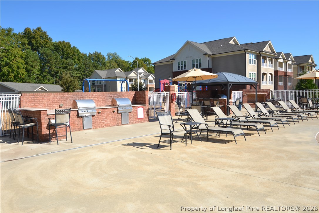 244 Amber Acorn Avenue Raleigh, NC 27603 - Photo 45 of 50 a view of a swimming pool with a table and chairs under an umbrella