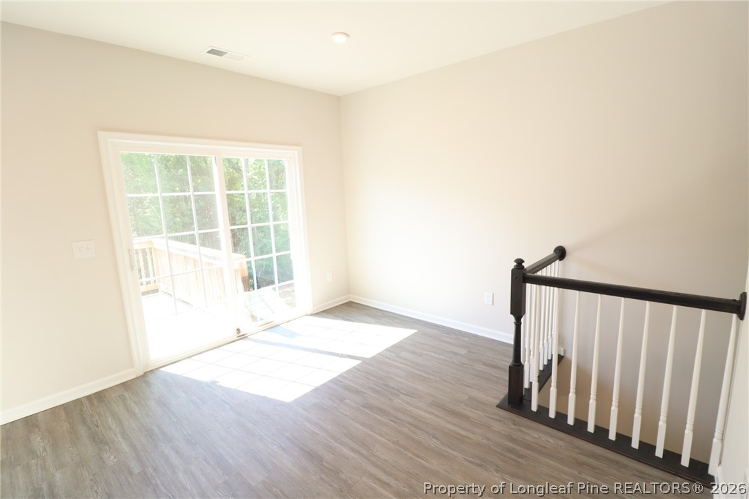 244 Amber Acorn Avenue Raleigh, NC 27603 - Photo 10 of 50 a view of an empty room with wooden floor and a window