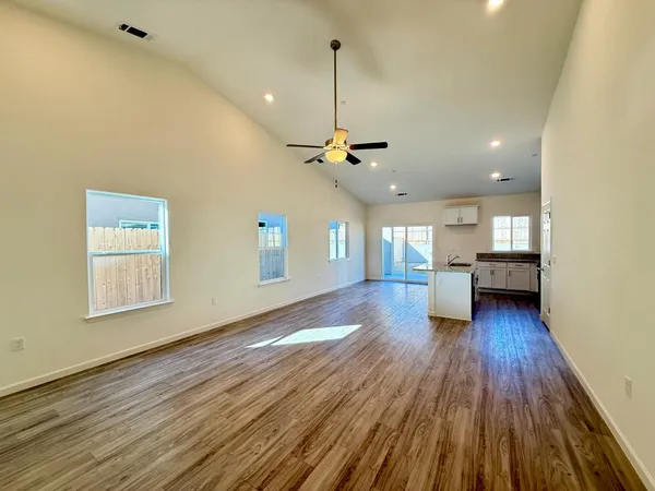 a view of a living room a kitchen and a wooden floor