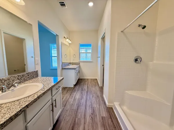 a bathroom with a granite countertop sink toilet and shower