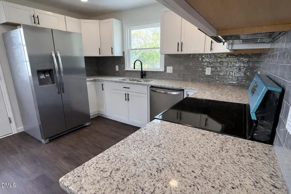 a kitchen with a sink a refrigerator and cabinets