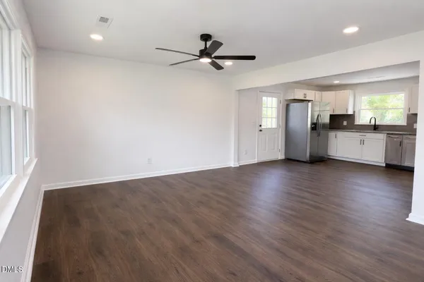 a view of a kitchen with wooden floor and a window