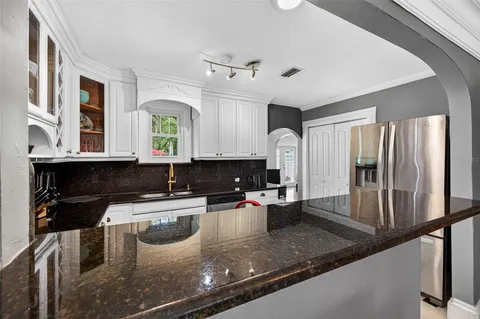 a kitchen with a sink a counter top space and stainless steel appliances