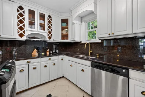a kitchen with stainless steel appliances granite countertop a sink and a window