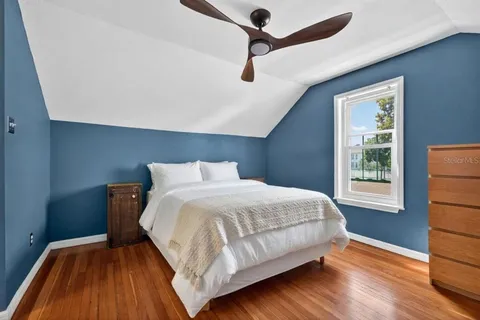 a bedroom with a bed and wooden floor