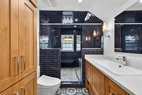 a bathroom with a sink a toilet and shower