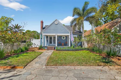 a front view of a house with a yard and potted plants