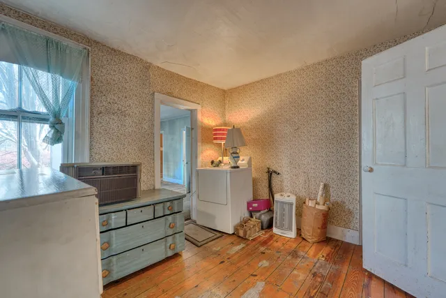 a room with a bed and a view of kitchen