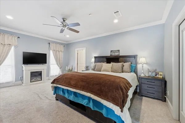 a spacious bedroom with a bed and a flat screen tv