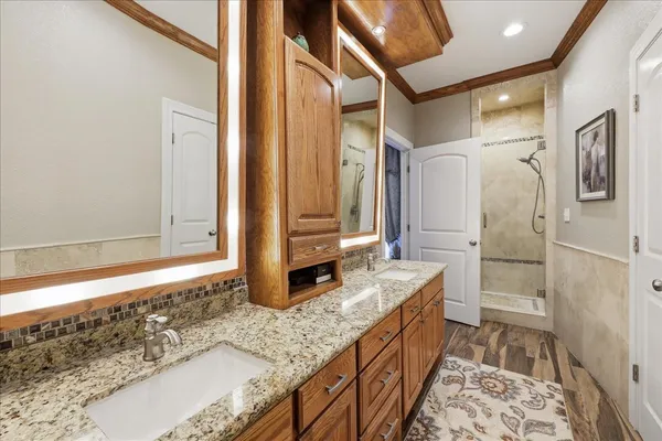 a bathroom with a granite countertop double vanity sink and a mirror