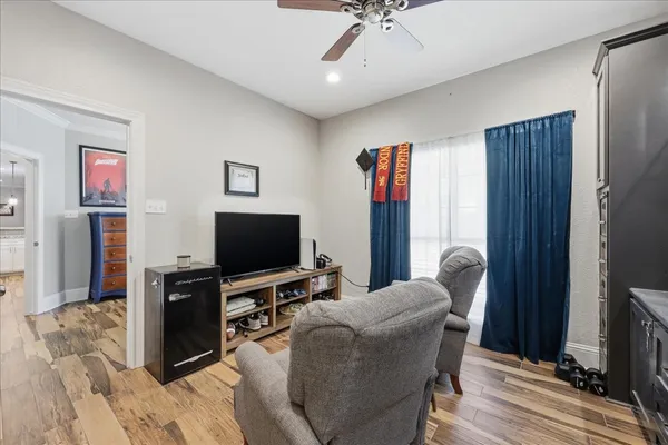a living room with furniture a chandelier and a flat screen tv