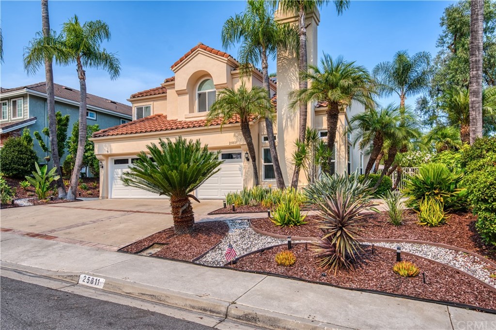 a view of a palm tree in front of a house with a patio