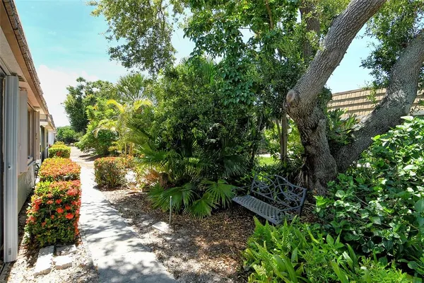 a view of swimming pool with a yard and palm trees