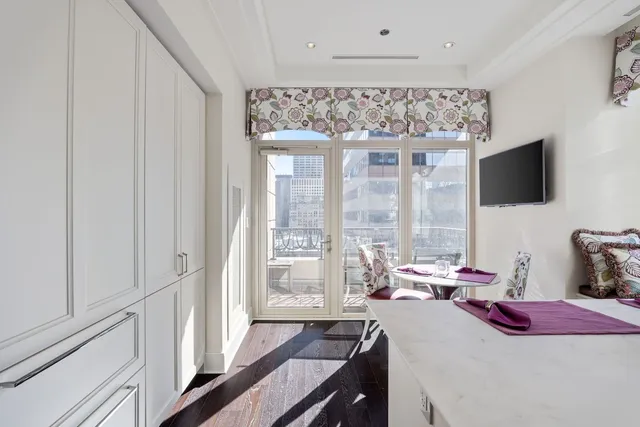 a bedroom with a bed and a flat tv screen on the dresser