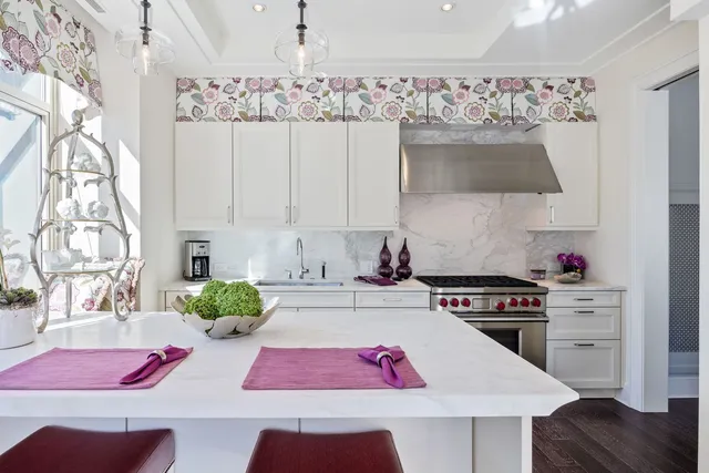 a kitchen with stainless steel appliances a stove a sink and white cabinets