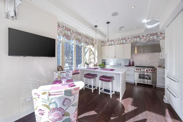 a dining room with a flat screen tv and a chandelier