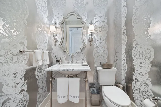 a white toilet sitting next to a bathroom sink