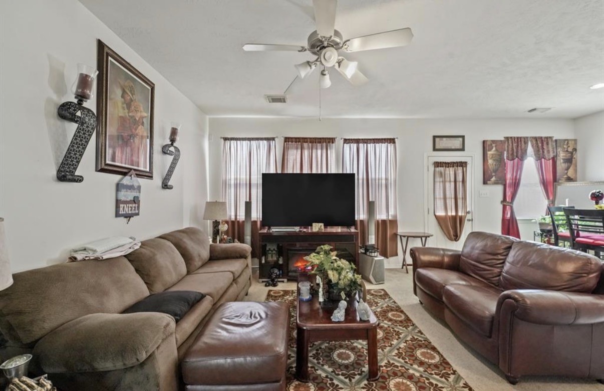 13134 Peppergate Lane Houston, TX 77044 - Photo 7 of 23 a living room with furniture a flat screen tv and a window