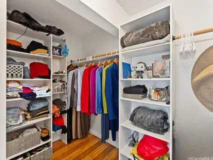 a view of walk in closet with clothes and shoes