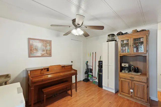 a kitchen with stainless steel appliances kitchen island granite countertop a dining table chairs and a refrigerator