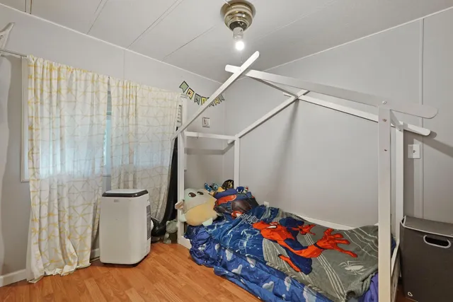 a bedroom with a bed and wooden floor