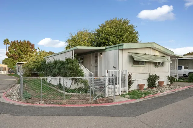 a view of a white house with large windows and a small yard