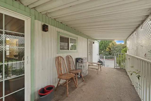 a view of a chair and table in backyard of the house