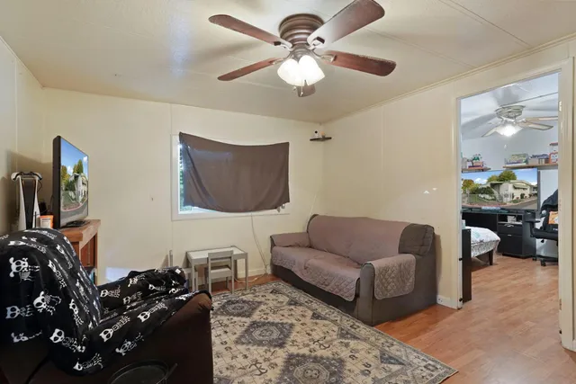 a living room with furniture a flat screen tv and a book shelf