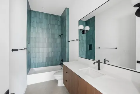 a bathroom with a sink a toilet and a mirror