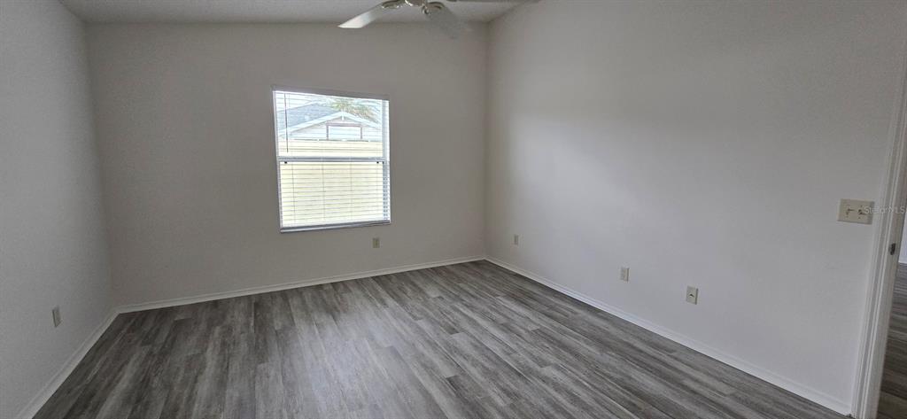 1009 Ridgeville Road The Villages, FL 32162 - Photo 12 of 16 an empty room with wooden floor and windows