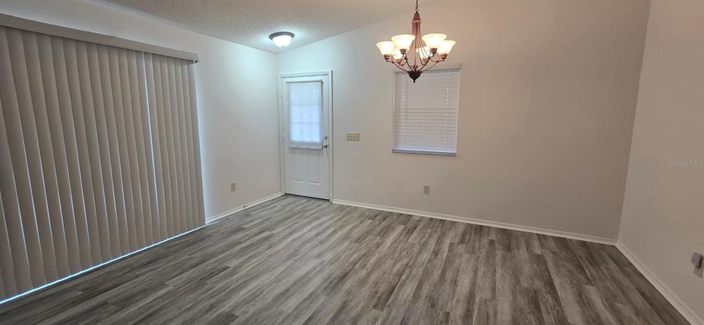 1009 Ridgeville Road The Villages, FL 32162 - Photo 7 of 16 wooden floor in an empty room with a window
