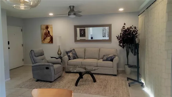 a living room with furniture and a potted plant