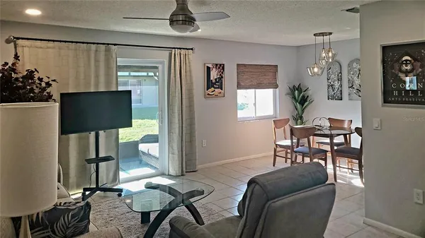a living room with furniture a flat screen tv and a chandelier