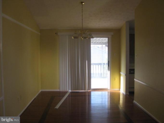 100 Sandhill Road Essex, MD 21221 - Photo 2 of 10 a view of a hallway with wooden floor and a window