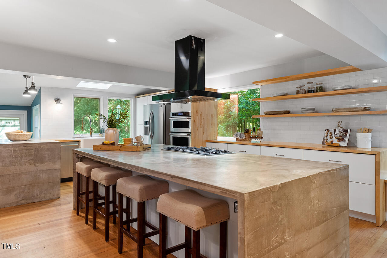 1607 Lorraine Road Raleigh, NC 27607 - Photo 14 of 37 a view of kitchen island a sink wooden floor and chairs