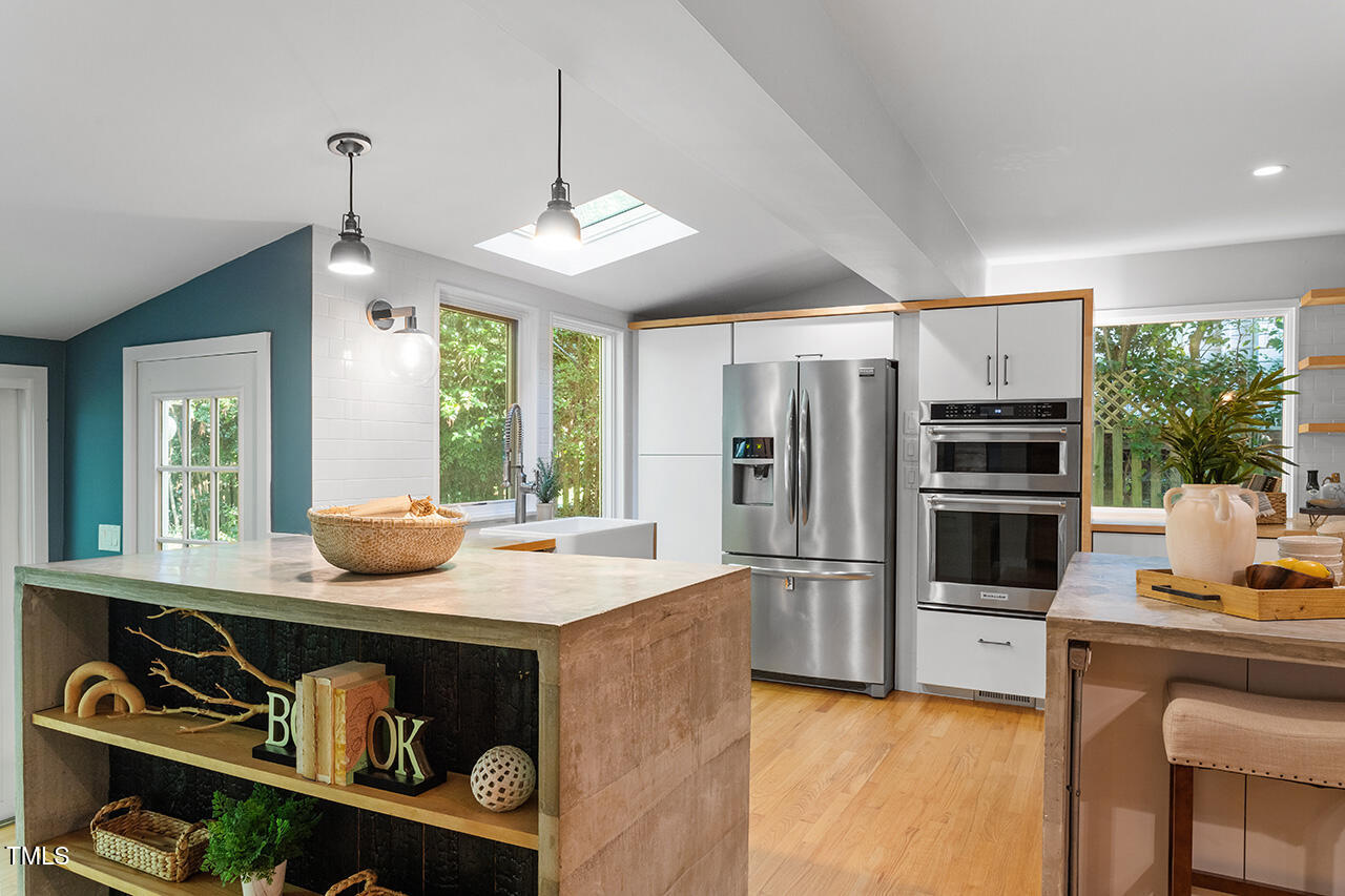 1607 Lorraine Road Raleigh, NC 27607 - Photo 15 of 37 a kitchen with stainless steel appliances kitchen island granite countertop a stove and a refrigerator