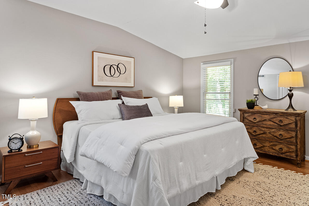 1607 Lorraine Road Raleigh, NC 27607 - Photo 26 of 37 a bedroom with bed and a chandelier