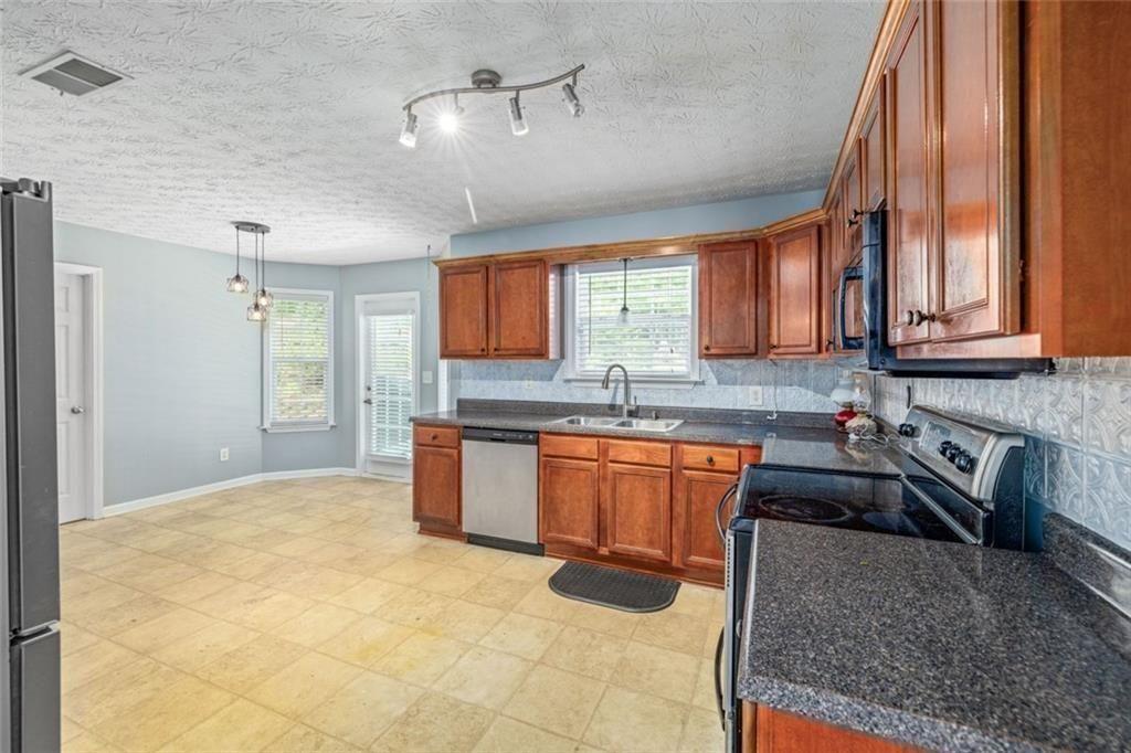 3286 High View Court Gainesville, GA 30506 - Photo 17 of 38 a kitchen with stainless steel appliances granite countertop a sink a stove cabinets counter space and a window