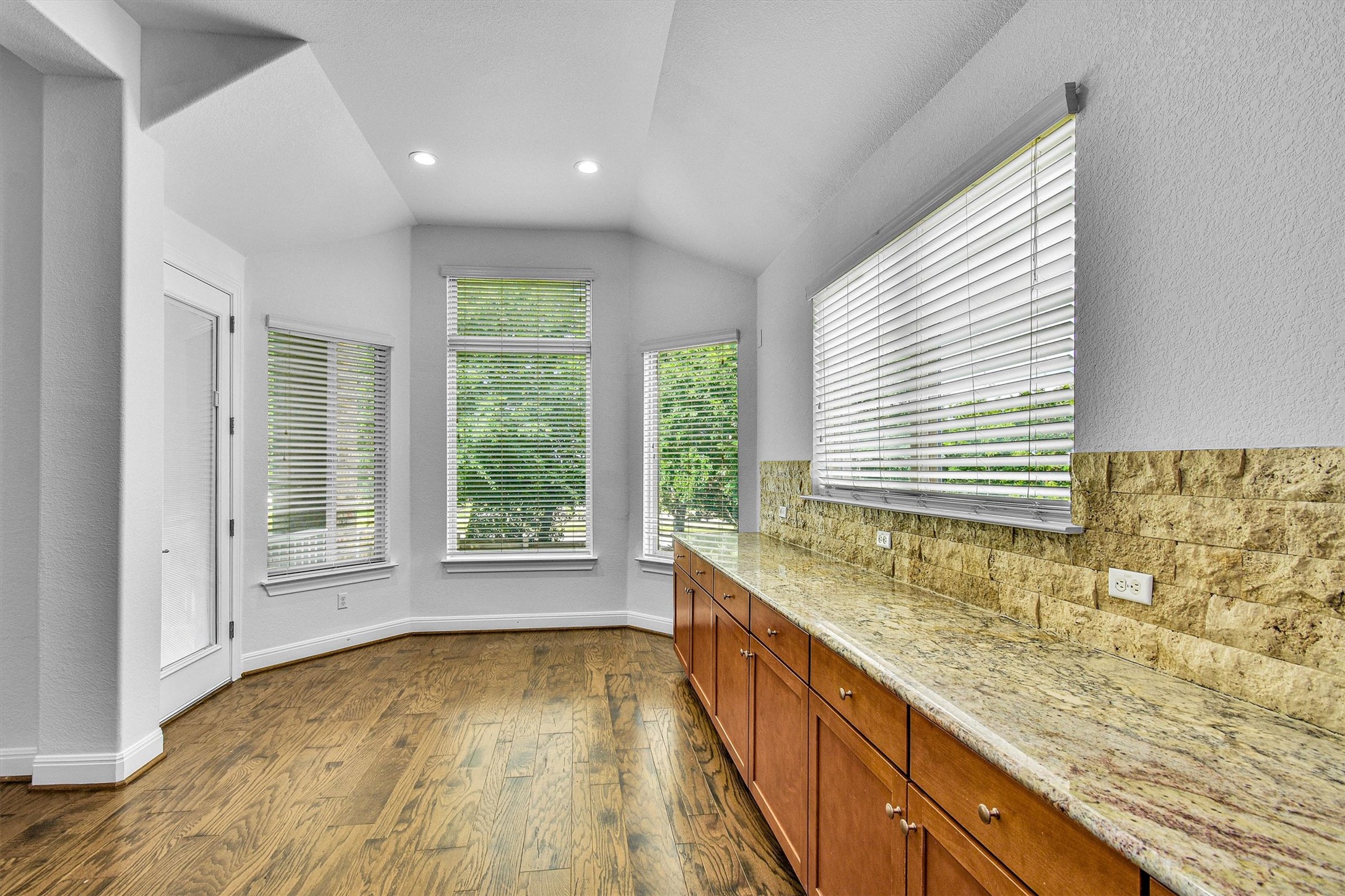 2325 Blended Tree Ranch Drive Leander, TX 78641 - Photo 14 of 35 A well-lit area with warm wood flooring and ample counter space, perfect for everyday living.