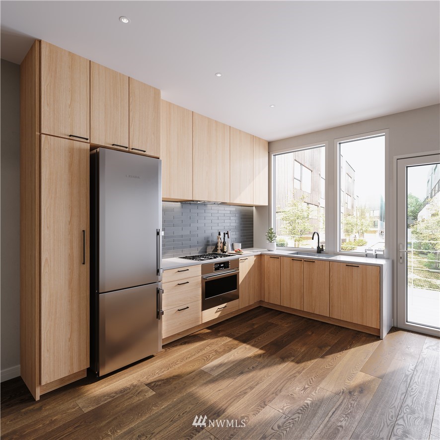 63 East Lynn Street Seattle, WA 98102 - Photo 3 of 20 a kitchen with granite countertop a refrigerator stove and wooden floor